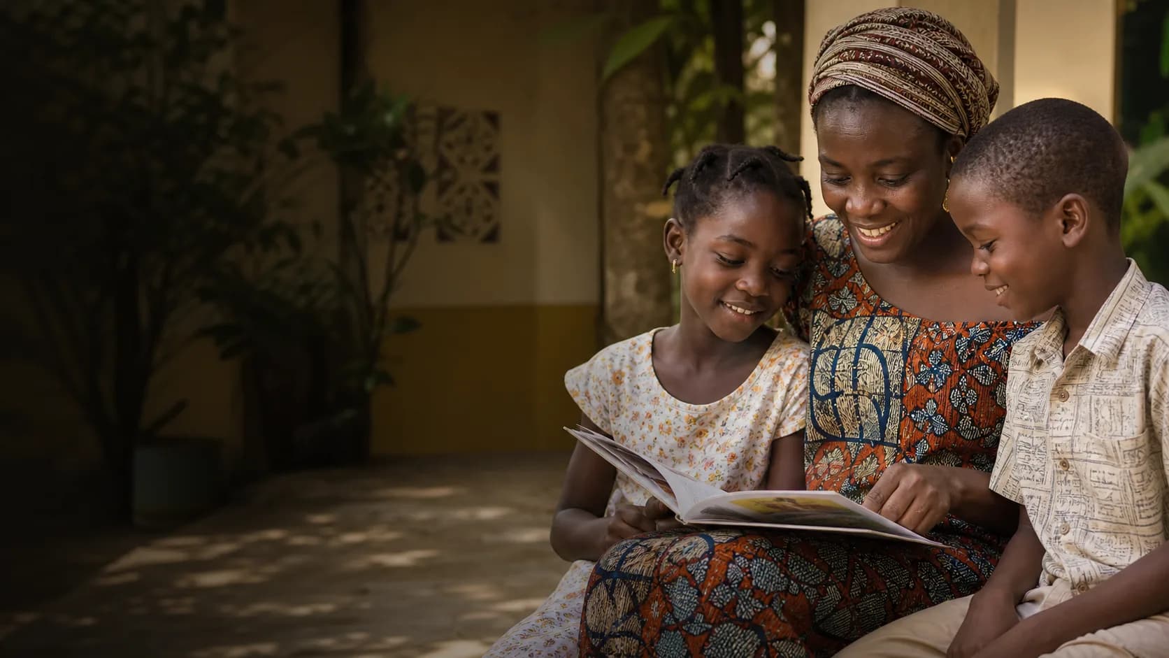 Une femme et deux enfants partagent un moment de lecture